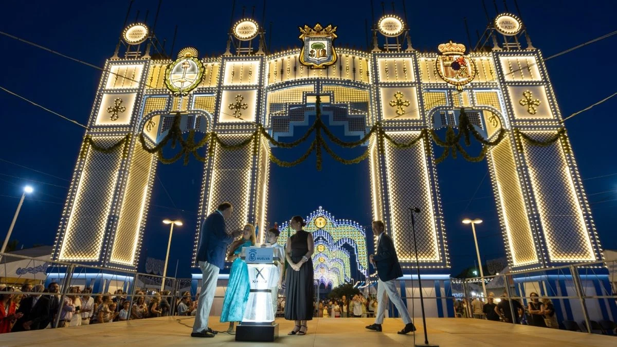 Imagen ilustrativa: arco monumental iluminado con luces LED frente a una ría nocturna, con el fondo de una ciudad