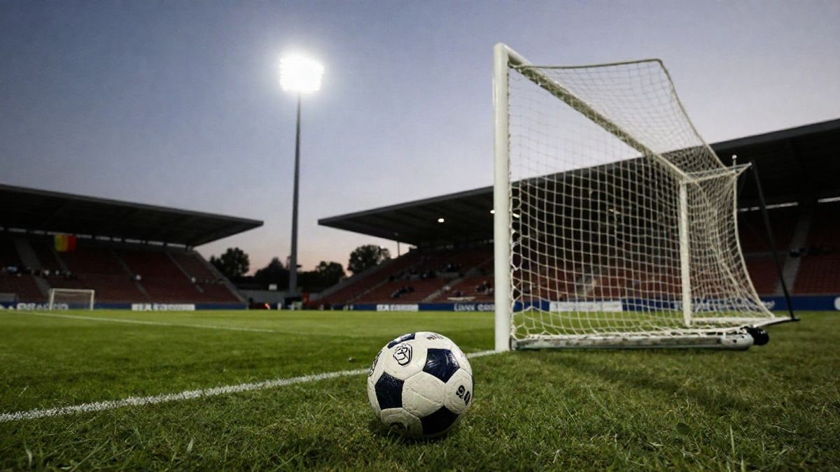 Imagen ilustrativa: balón de fútbol en el punto de penalti de un campo al atardecer, con focos de fondo.