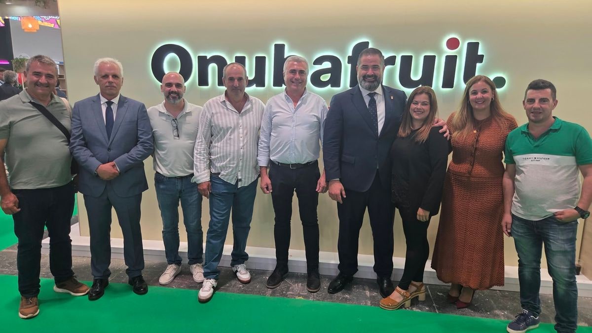 Imagen ilustrativa: pabellón ferial con expositores y cajas de productos hortofrutícolas en primer plano