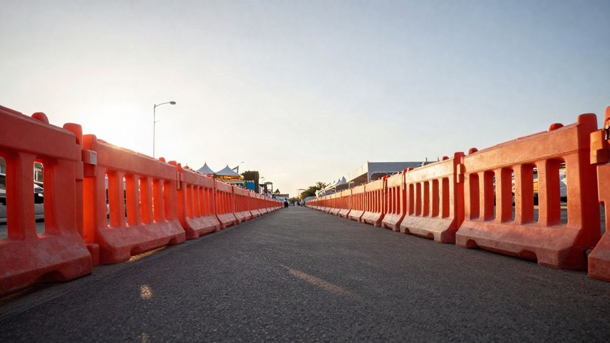 Imagen ilustrativa: avenida urbana con vallas naranjas y conos de tráfico bajo un cielo amplio al atardecer