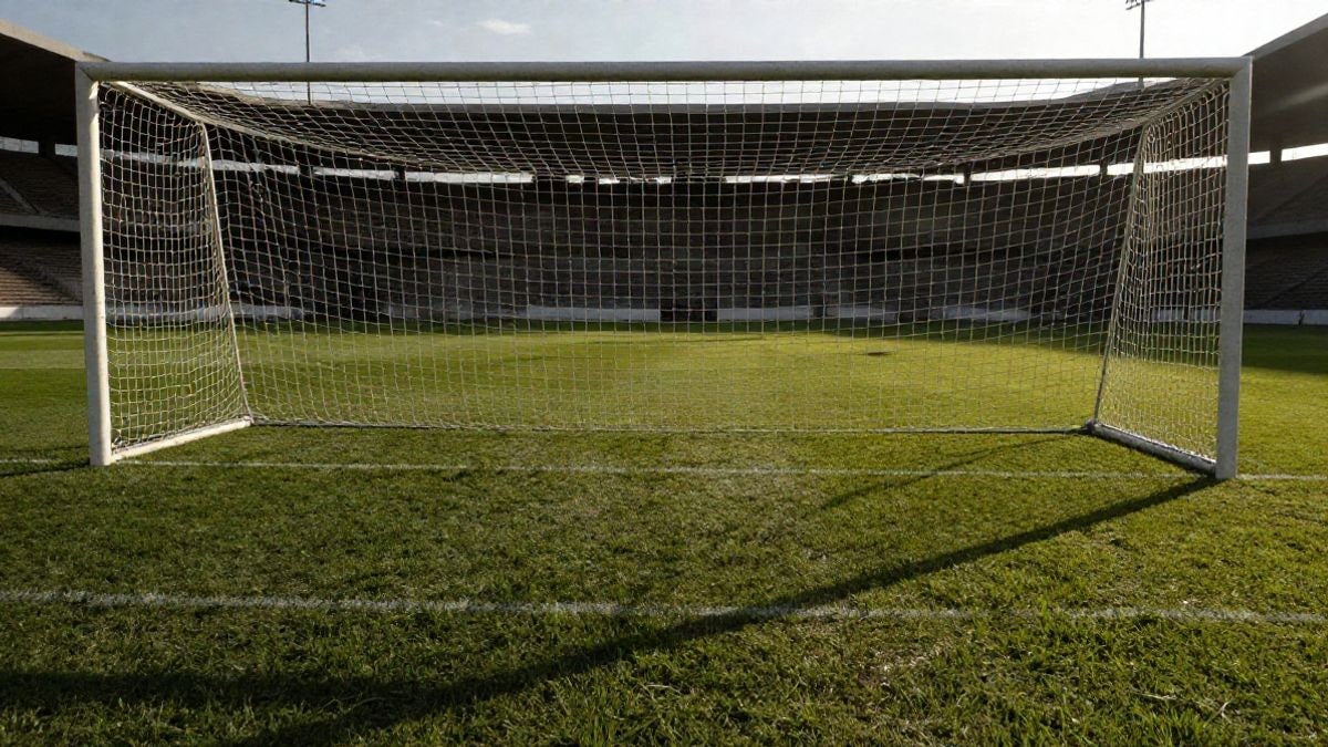 Imagen ilustrativa: portería de fútbol con red vista desde el punto de penalti en un campo municipal