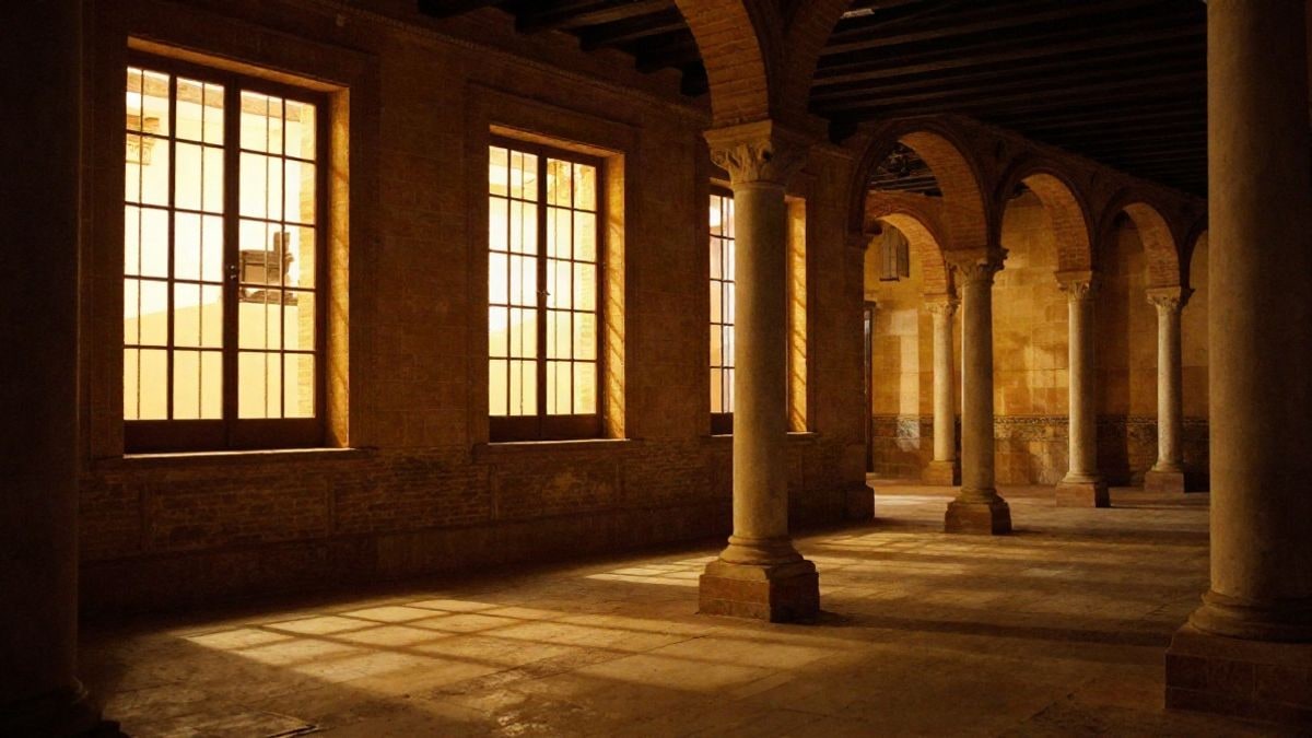 Imagen ilustrativa: interior de un edificio histórico español con luz cálida de ventanas laterales