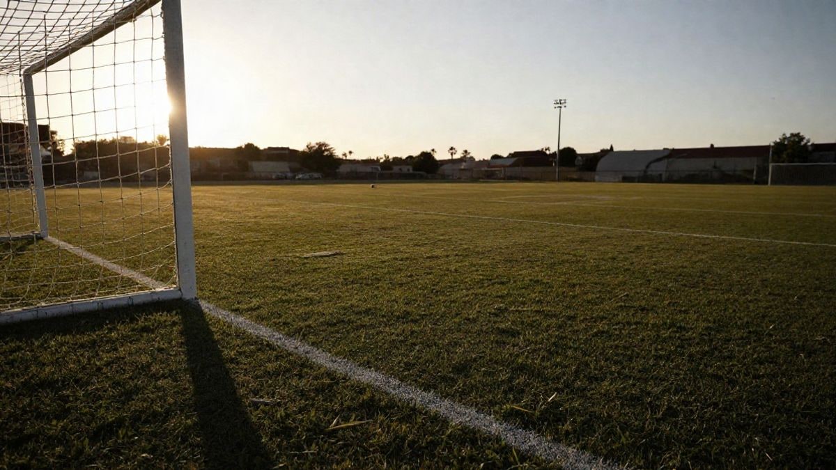 Imagen ilustrativa: portería de fútbol con la red al atardecer y un balón en el punto de penalti