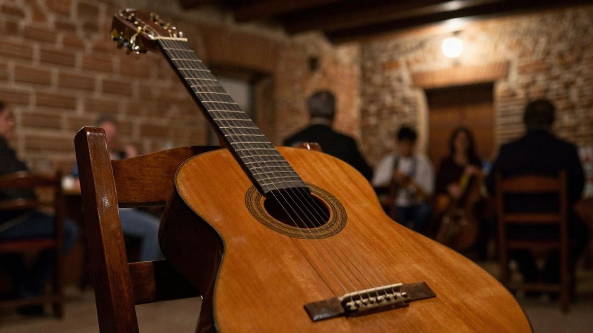 Imagen ilustrativa: guitarra española sobre una silla en un local de ambiente flamenco