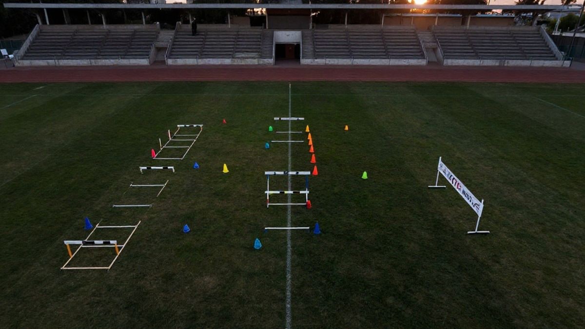 Imagen ilustrativa: circuito de obstáculos con conos y vallas en un campo de fútbol al atardecer, visto desde arriba
