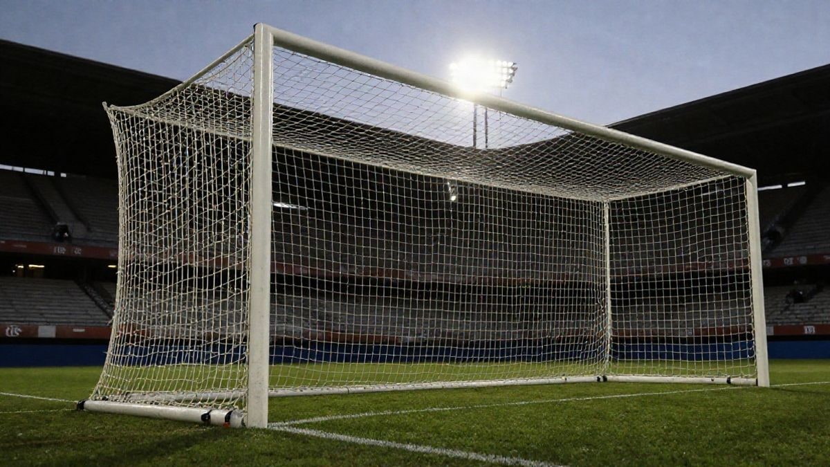 Imagen ilustrativa: red de portería de fútbol iluminada al atardecer en un estadio genérico