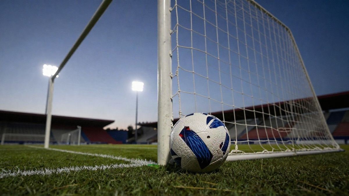 Imagen ilustrativa: una red de portería de fútbol con un balón en la base, iluminada por la luz del atardecer.