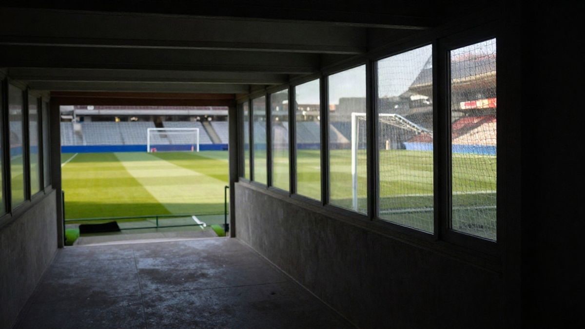 Imagen ilustrativa: túnel de vestuarios que conduce al césped de un estadio de fútbol con luz lateral