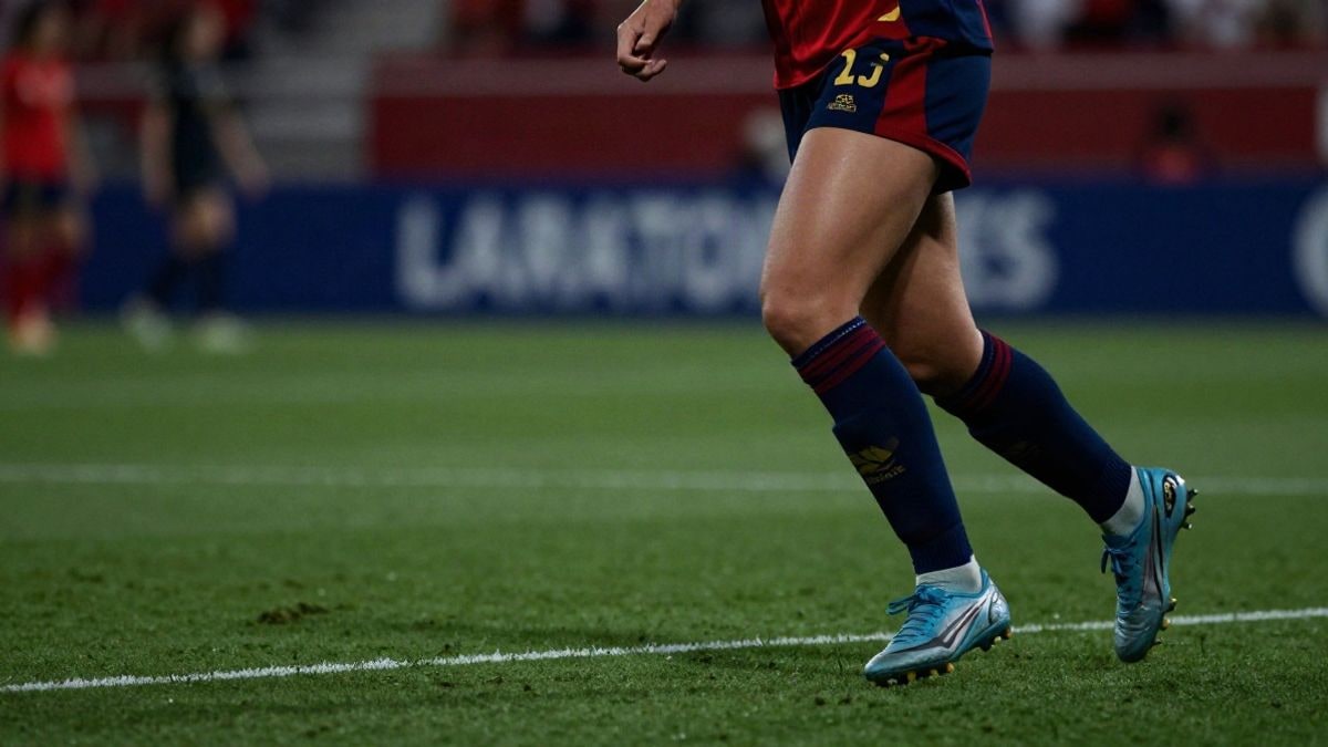 Imagen ilustrativa: piernas de una futbolista en movimiento durante un partido, con fondo de césped desenfocado