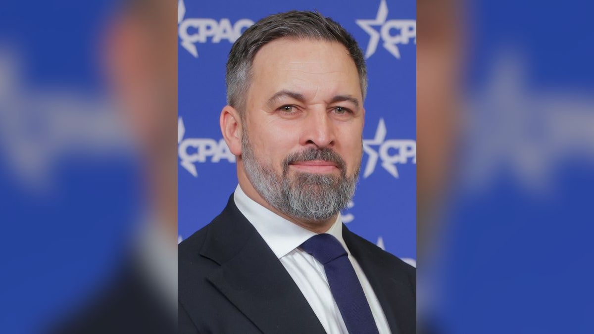 Santiago Abascal, líder de Vox, posando con traje azul marino ante el fondo del CPAC
