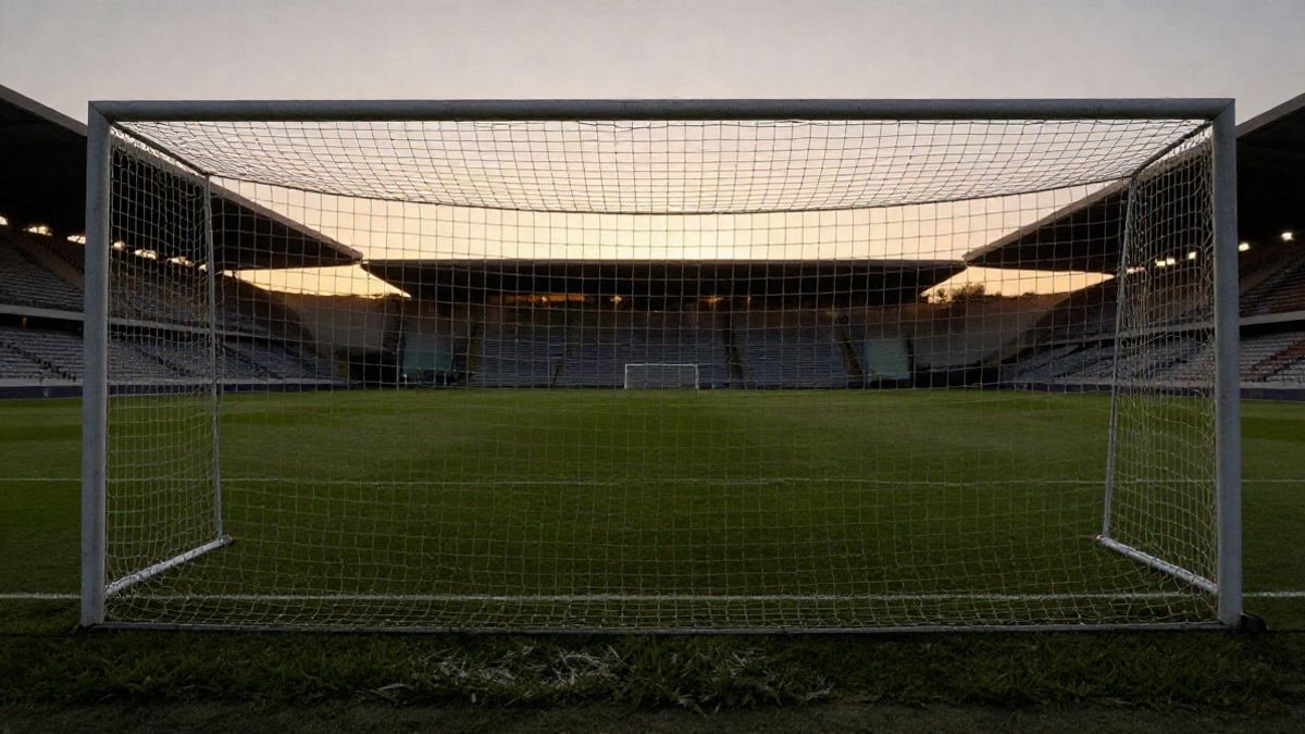 Imagen ilustrativa: campo de fútbol al atardecer con la portería y la red recortadas a contraluz