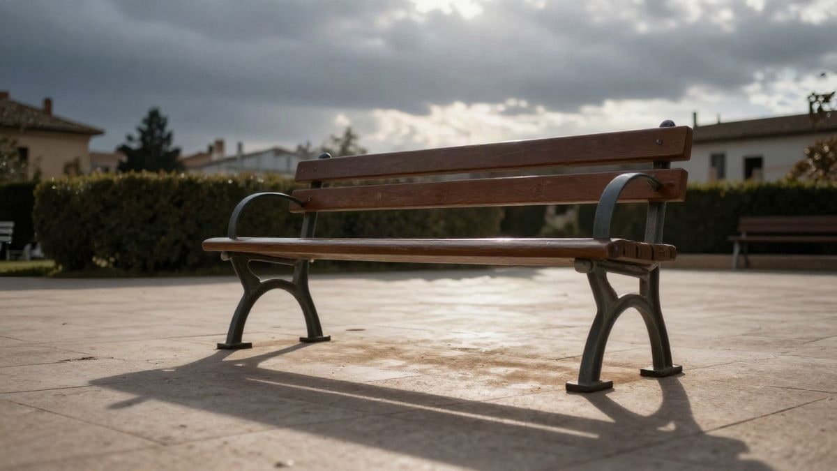 Imagen ilustrativa: banco de madera vacío en un patio tranquilo, con un cielo de atardecer de fondo y sombras largas sobre el suelo