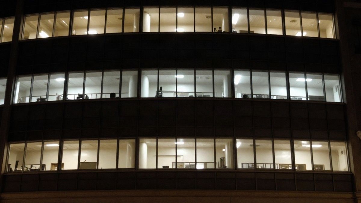 Imagen ilustrativa: edificio de oficinas con luces encendidas por la noche