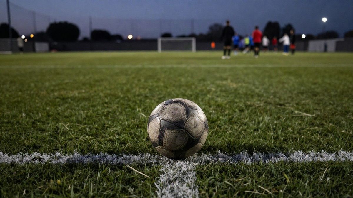 Imagen ilustrativa: un balón de fútbol sobre el césped de un estadio al atardecer, con las luces de fondo.