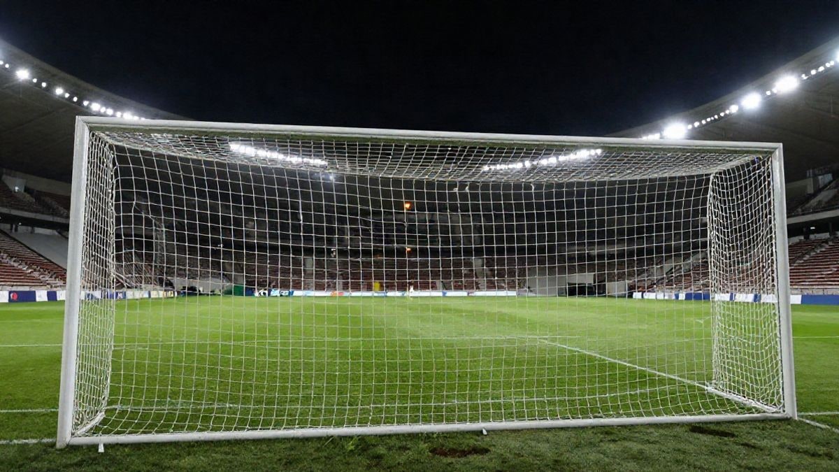 Imagen ilustrativa: portería de fútbol iluminada por focos en un estadio nocturno