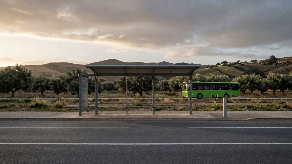 Imagen ilustrativa: un autobús regional detenido en una parada rural al amanecer, con colinas de fondo.