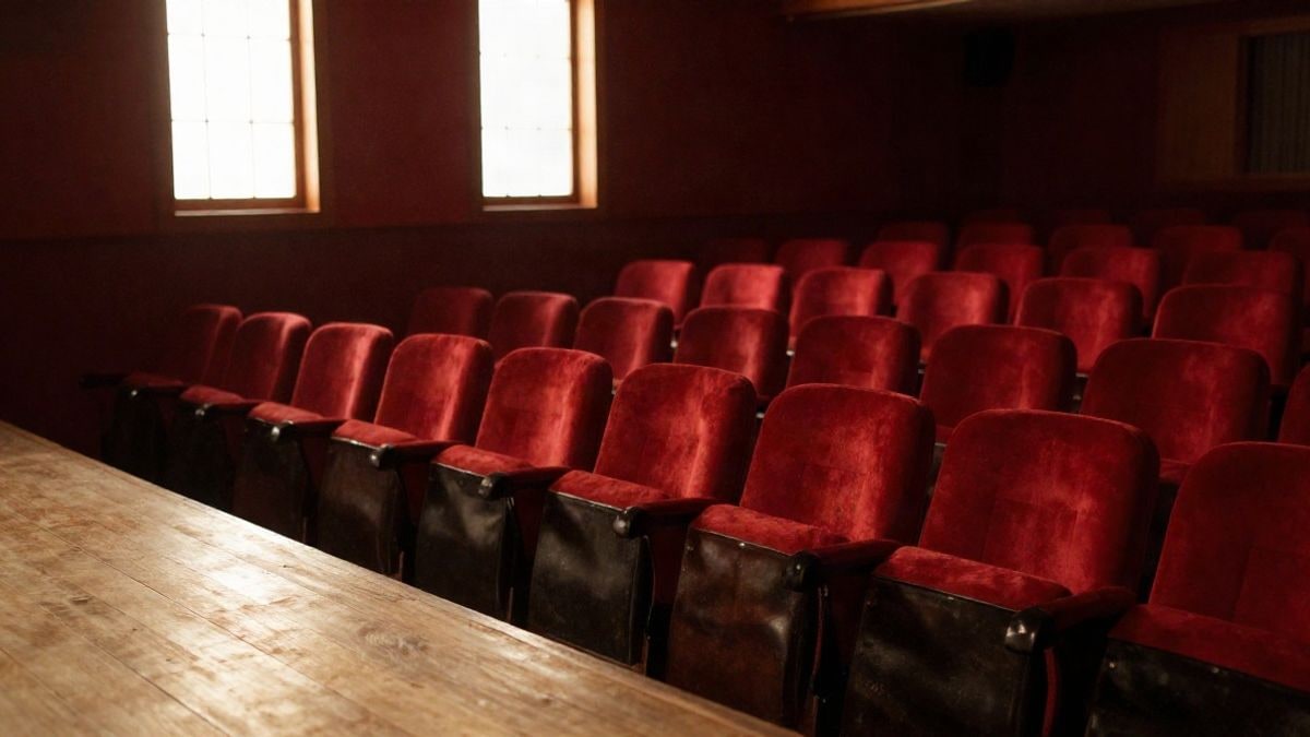 Imagen ilustrativa: interior de un teatro vacío con butacas y luz lateral entrando por una ventana
