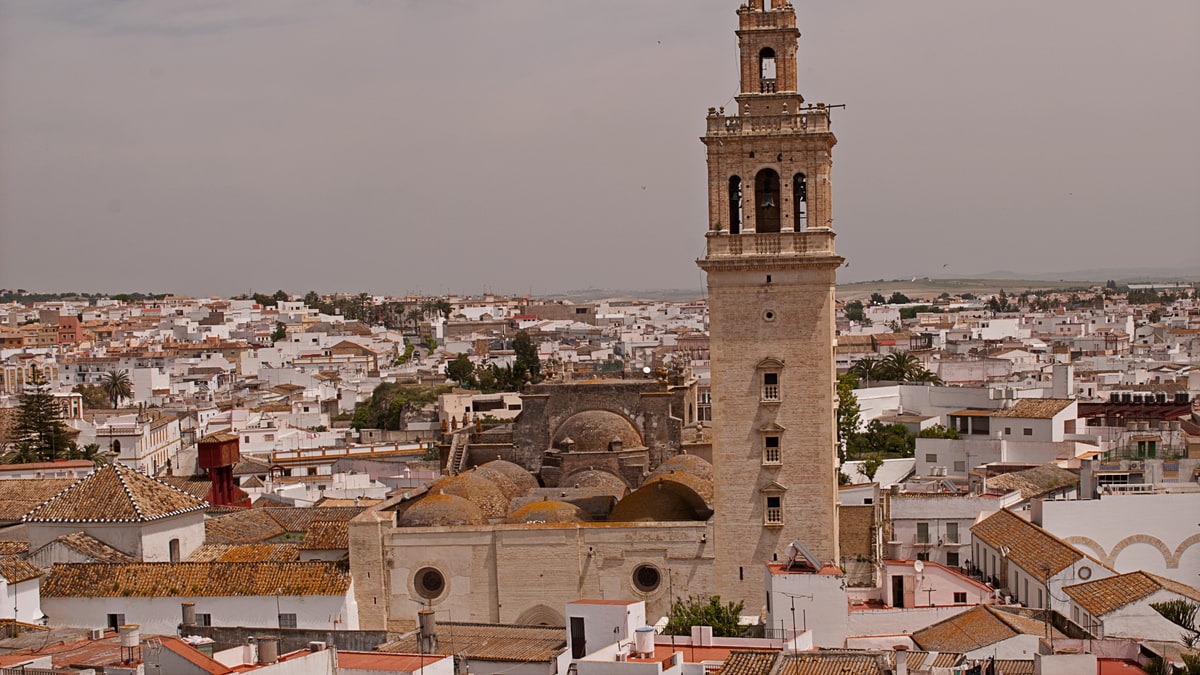 Vista aérea del casco urbano de Lebrija con la torre de su iglesia destacada entre tejados