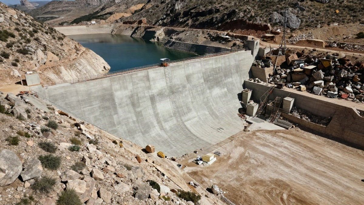 Imagen ilustrativa: vista cenital de una presa de hormigón en construcción en un paisaje árido