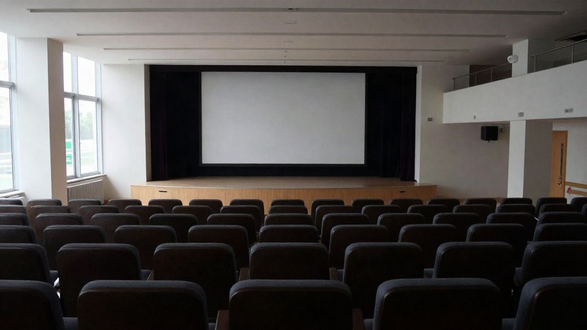 Imagen ilustrativa: un auditorio vacío y moderno con luz natural entrando por ventanales laterales.