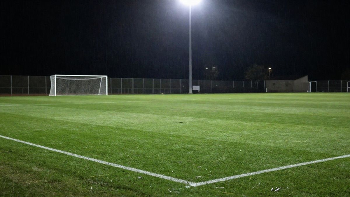 Imagen ilustrativa: campo de fútbol de noche iluminado por focos, con la portería al fondo