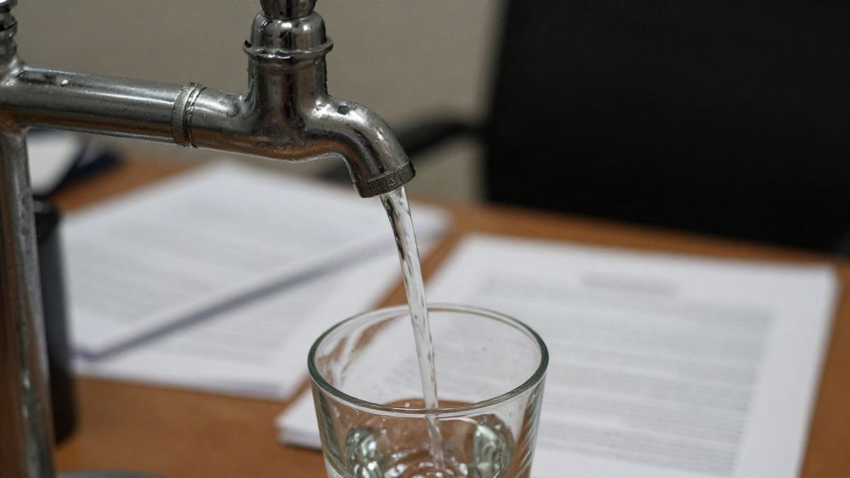 Imagen ilustrativa: un grifo goteando agua sobre un vaso, con documentos legales desenfocados al fondo.