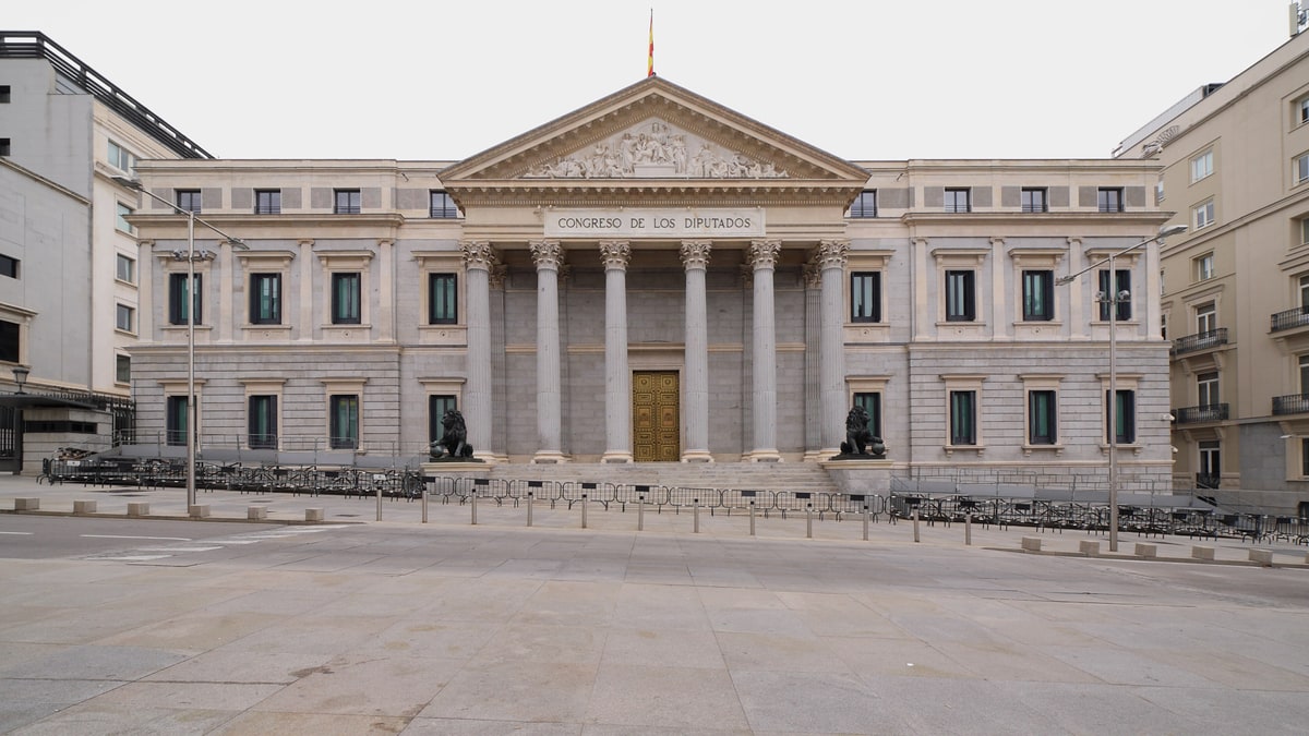 Fachada completa del Congreso de los Diputados en Madrid con su pórtico de columnas y plaza vacía.