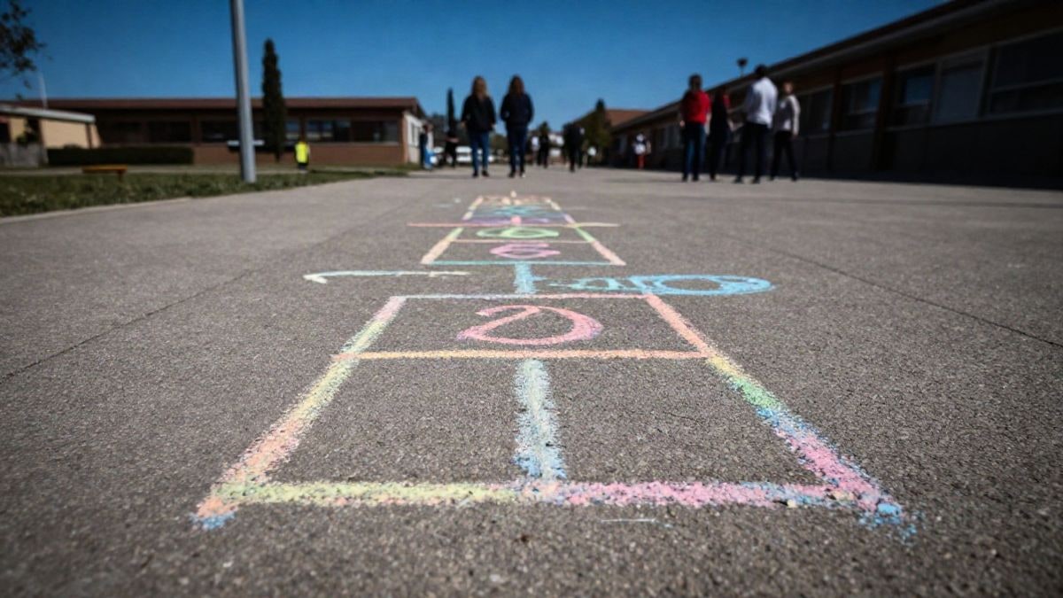 Imagen ilustrativa: patio escolar con un juego dibujado con tiza en el suelo y cielo despejado al fondo