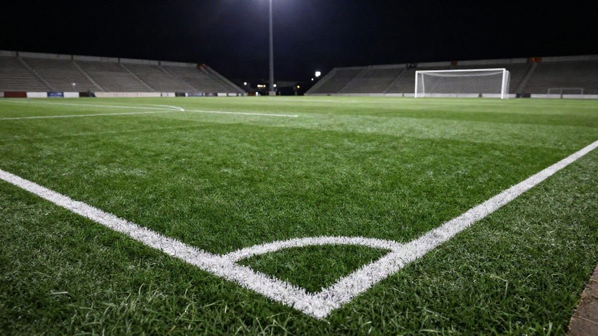 Imagen ilustrativa: campo de fútbol iluminado por focos en un partido nocturno