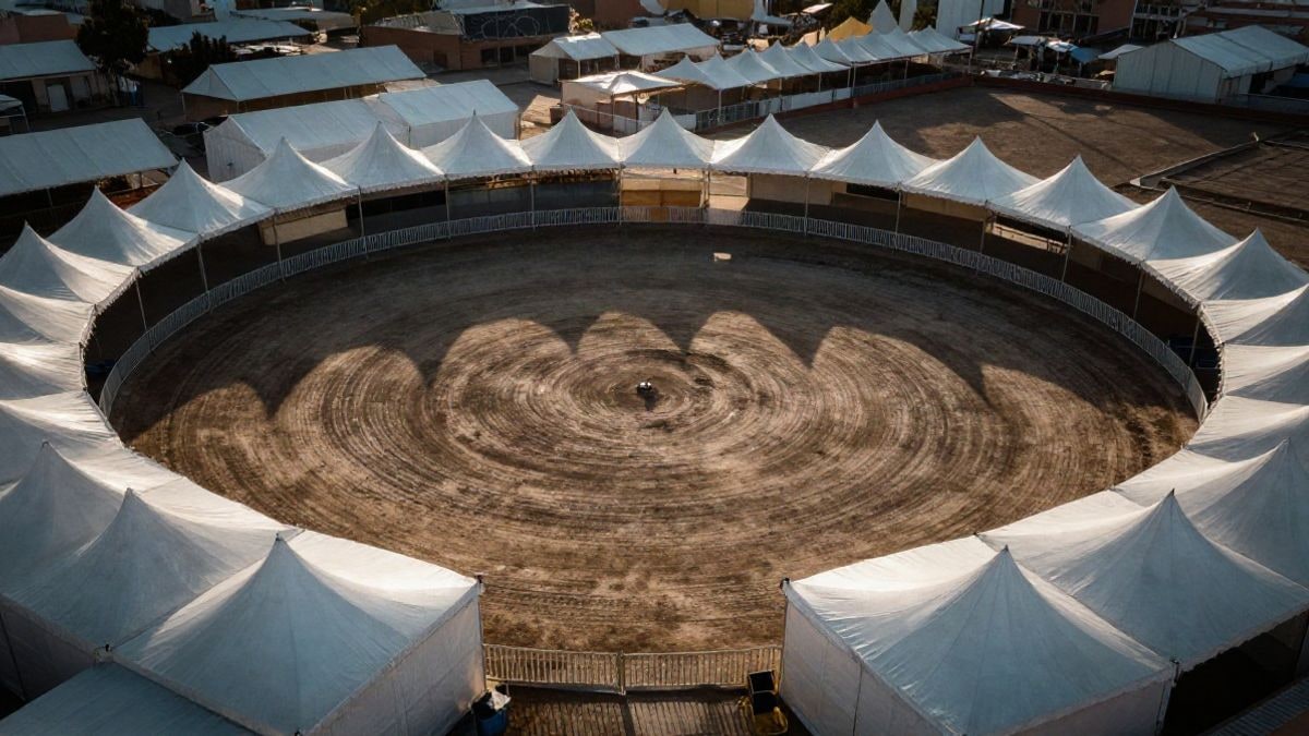 Imagen ilustrativa: vista cenital de un recinto ferial con casetas blancas y una pista de tierra