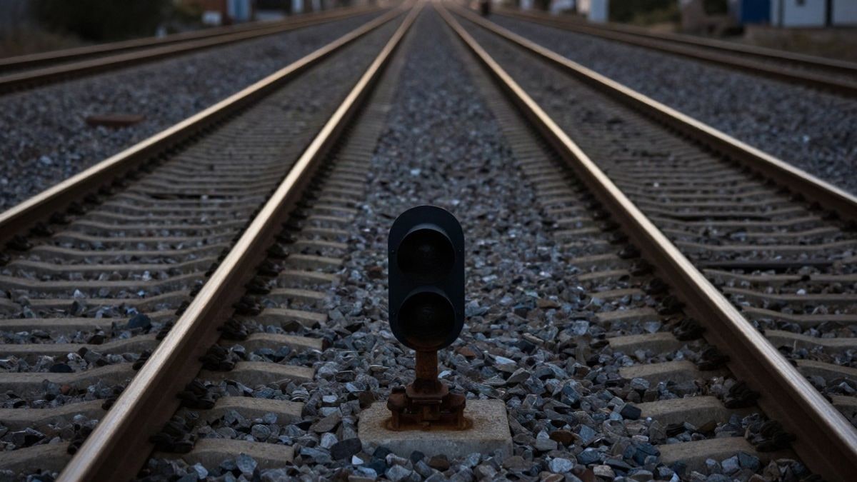 Imagen ilustrativa: vías de tren que convergen hacia el horizonte al atardecer, con sombras largas sobre la grava