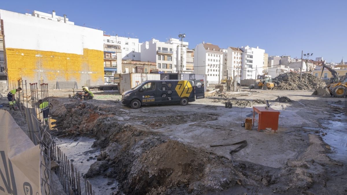 Imagen ilustrativa: obras de construcción en un solar entre edificios antiguos, con maquinaria y movimiento de tierras