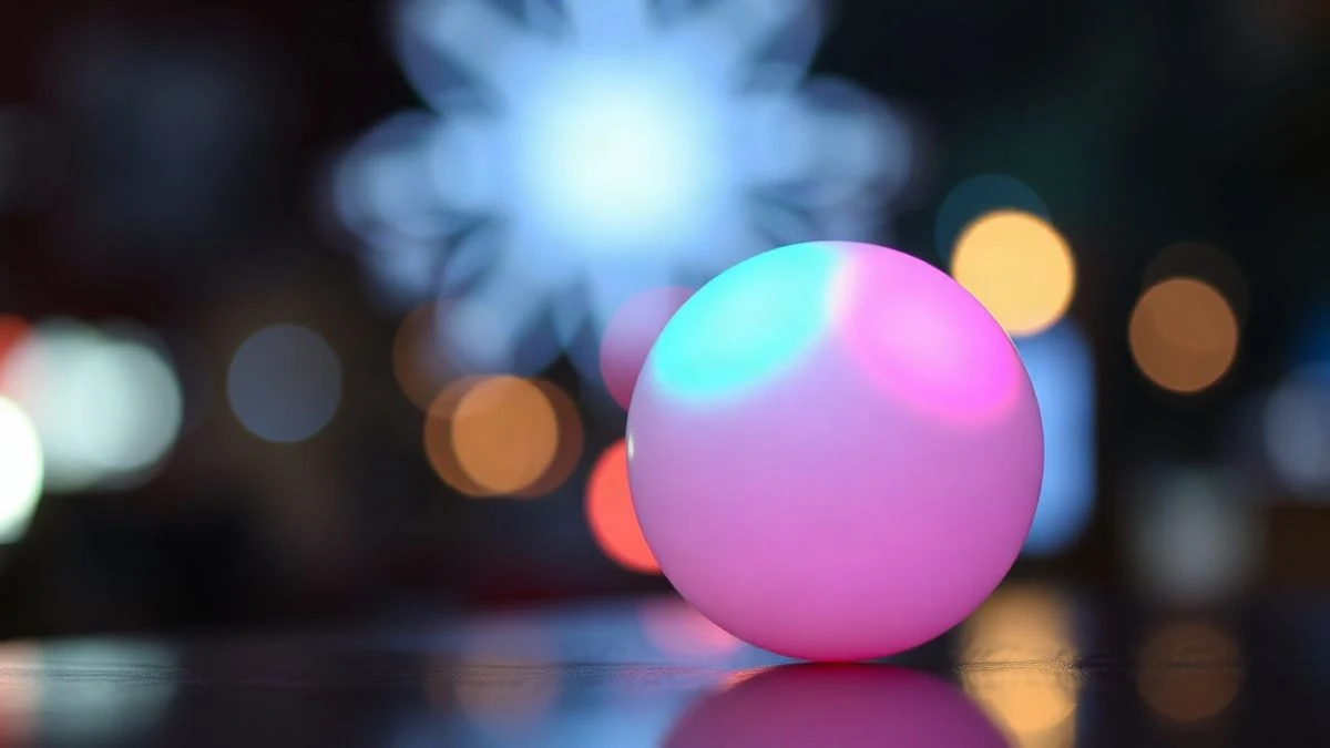 Imagen ilustrativa: una bola luminosa de colores sobre una superficie, con luces de fondo desenfocadas, evocando una actividad de premios nocturna.