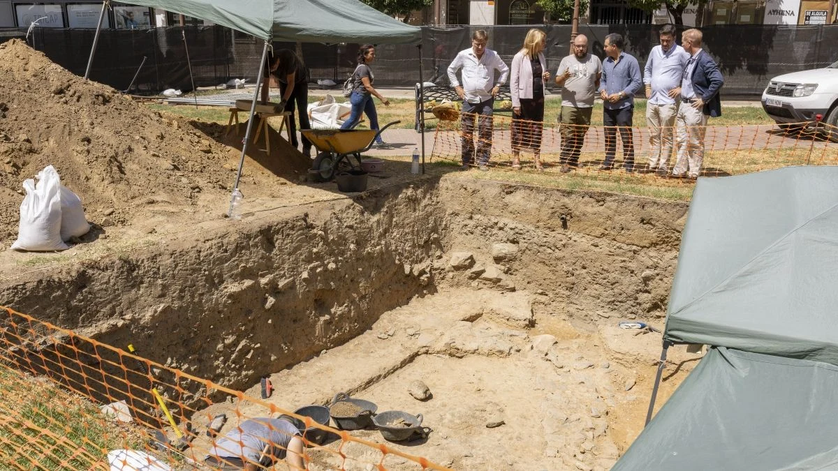 Imagen ilustrativa: excavación arqueológica con restos de muros y cerámica antigua bajo la luz del atardecer.