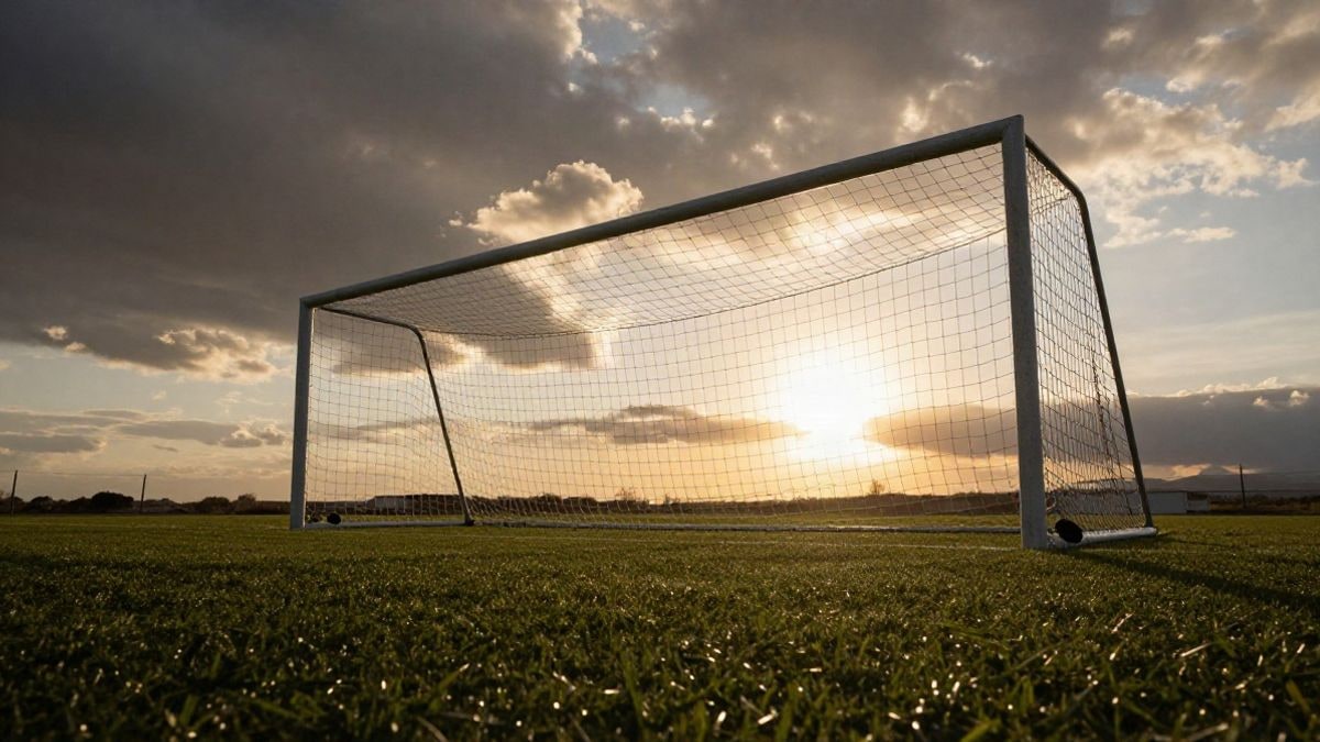 Imagen ilustrativa: portería de fútbol con la red a contraluz bajo un cielo al atardecer