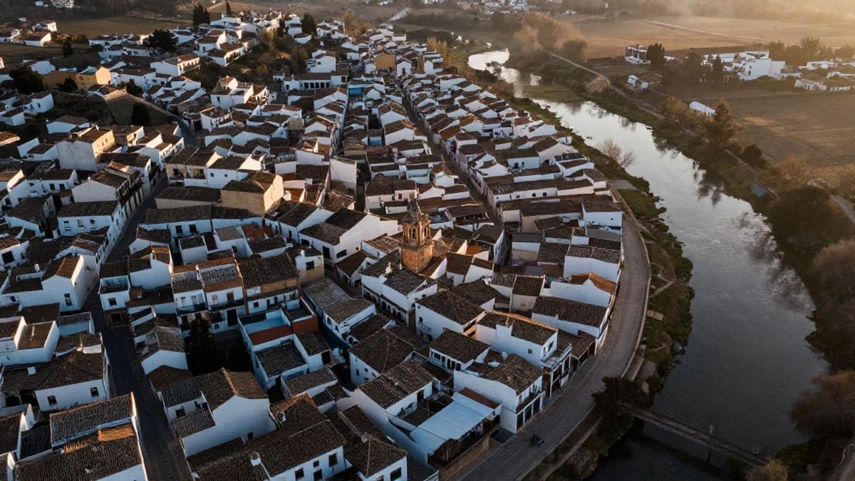 Imagen ilustrativa: vista cenital de un pueblo andaluz junto a una zona de agua estancada al atardecer