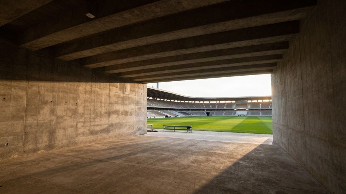 Imagen ilustrativa: un túnel de hormigón de un estadio de fútbol que conduce a un campo verde iluminado al atardecer