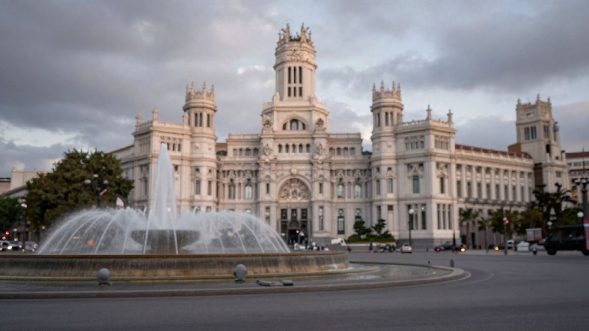 Imagen ilustrativa: la plaza de Cibeles vacía al atardecer, con la fuente en primer plano y el edificio del Ayuntamiento desenfocado al fondo