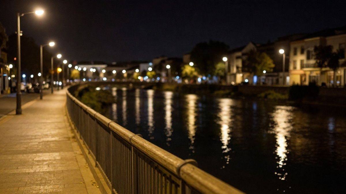 Imagen ilustrativa: paseo fluvial nocturno iluminado por farolas, con el agua oscura reflejando las luces