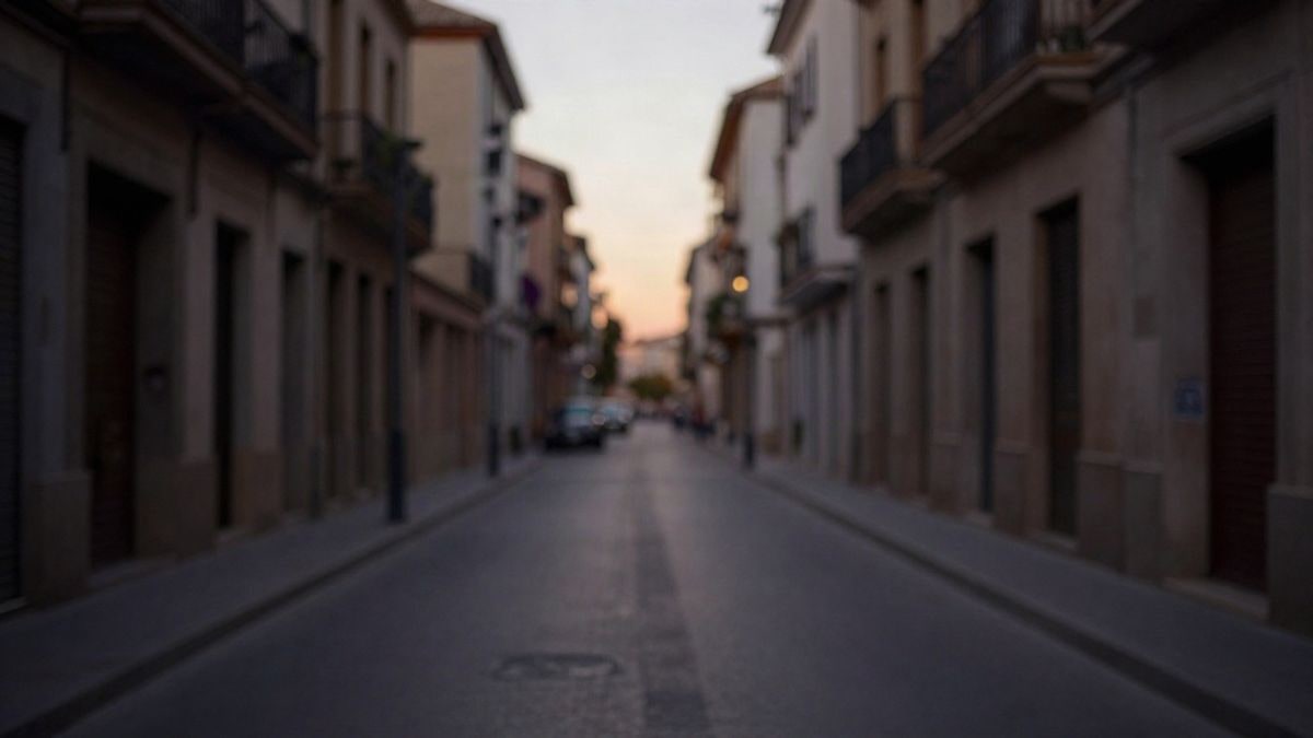 Imagen ilustrativa: manos de un agente con radio en una calle vacía al atardecer