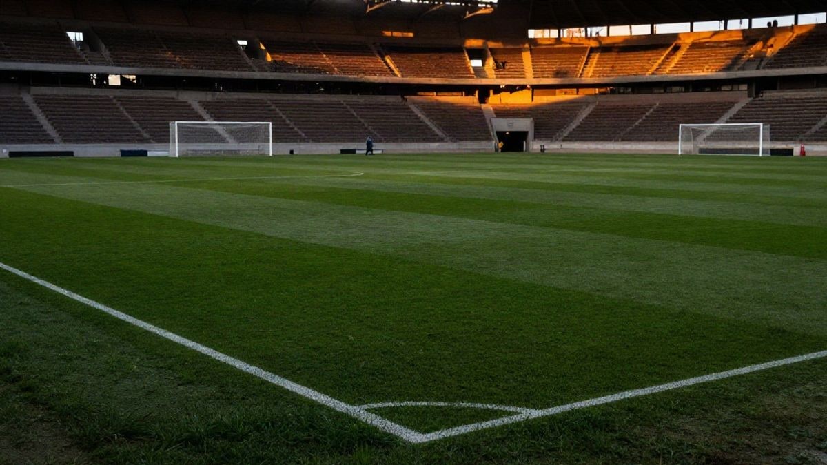 Imagen ilustrativa: campo de fútbol vacío al atardecer con la portería al fondo