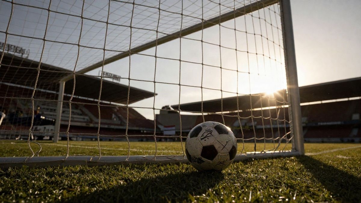 Imagen ilustrativa: ángulo bajo de una portería de fútbol con el balón en la red al atardecer