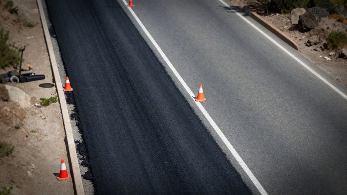 Imagen ilustrativa: vista cenital de una carretera en obras con conos de señalización y una franja de asfalto nuevo
