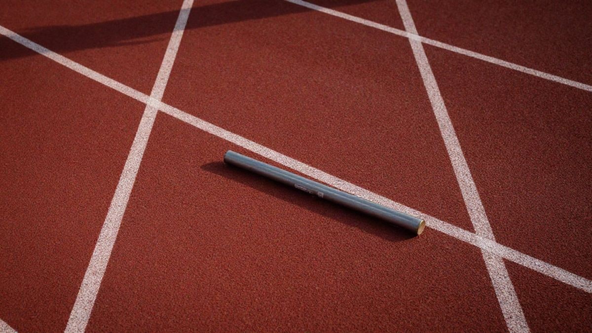 Imagen ilustrativa: vista cenital de una pista de atletismo con un testigo de relevos sobre la calle