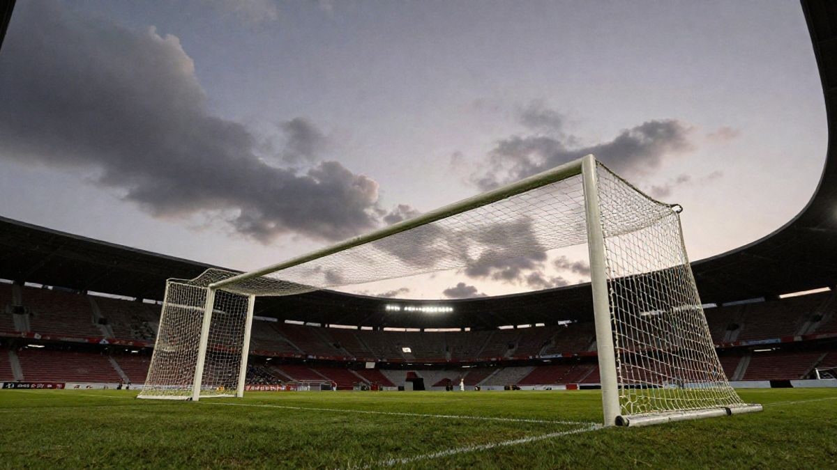 Imagen ilustrativa: ángulo bajo de una portería de fútbol con la red recortada contra el cielo al atardecer