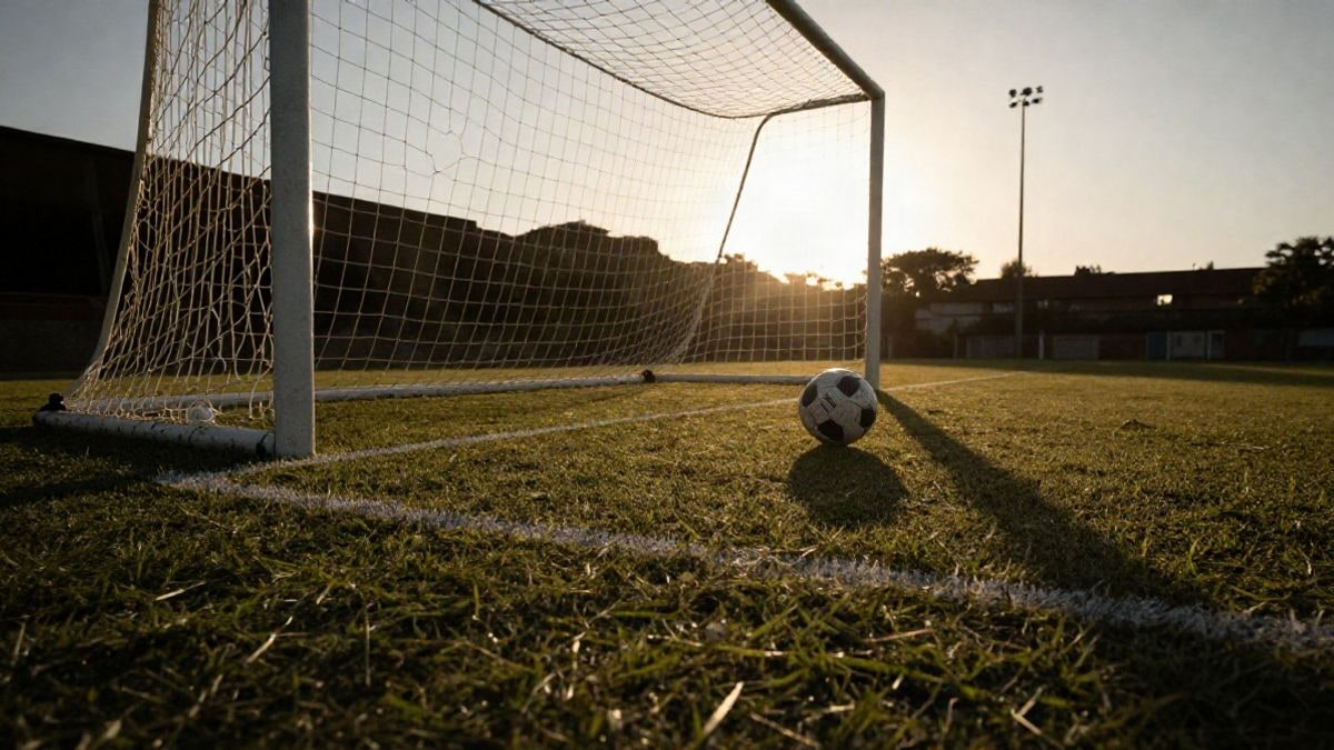Imagen ilustrativa: portería de fútbol con balón en el punto de penalti al atardecer
