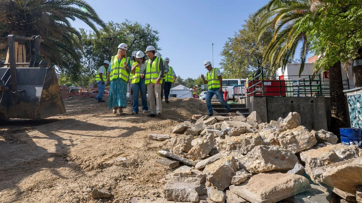 Imagen ilustrativa: obras de urbanización en un barrio español al atardecer, con maquinaria y terreno excavado.