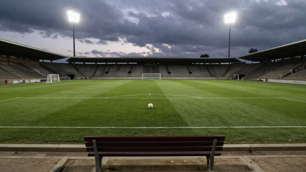 Imagen ilustrativa: un campo de fútbol vacío con un balón en el punto de penalti bajo la luz de los focos