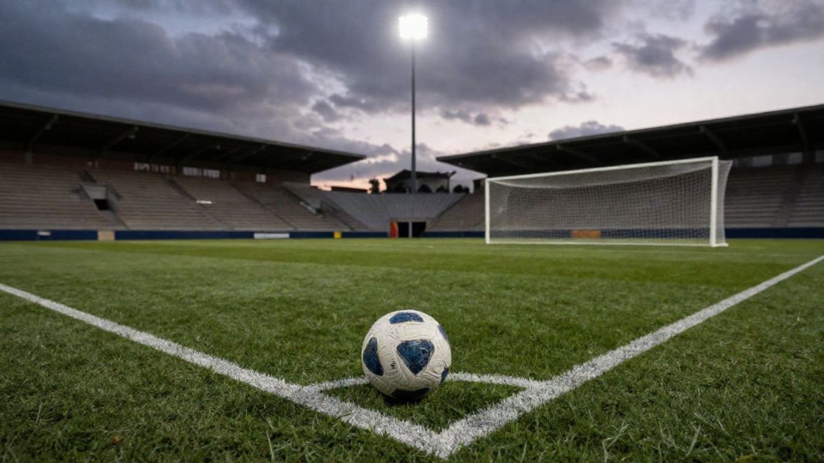 Imagen ilustrativa: un campo de fútbol vacío al atardecer con un balón en el punto de penalti