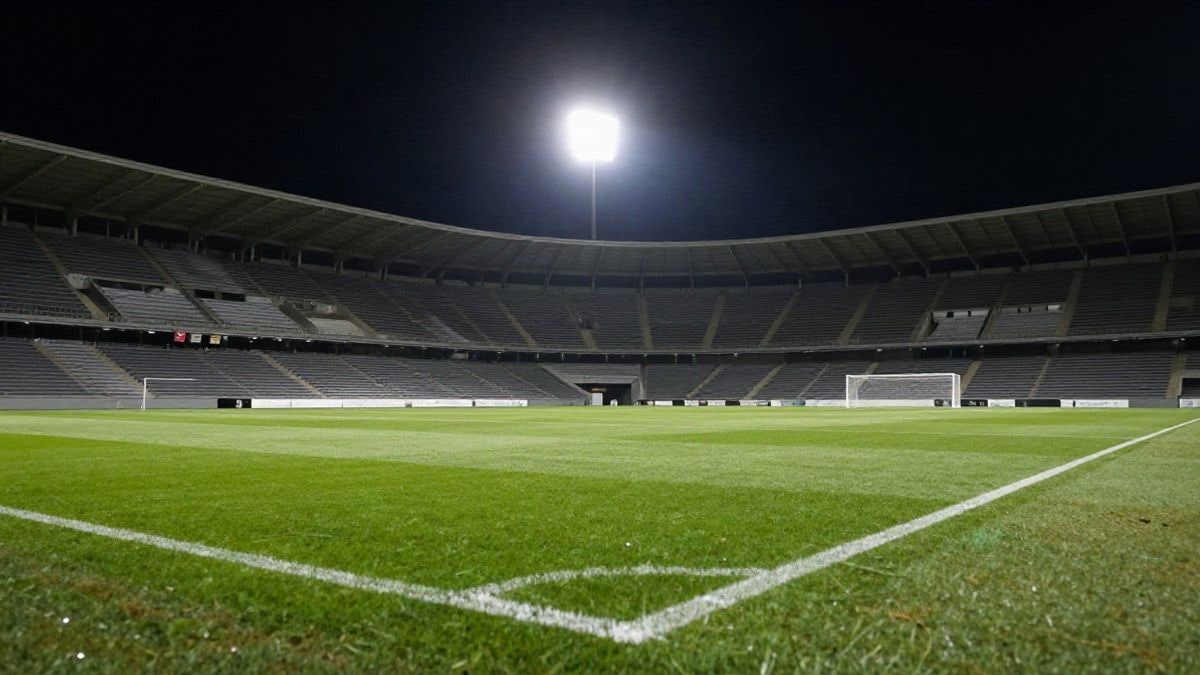 Imagen ilustrativa: estadio de fútbol genérico de noche con las gradas vacías y los focos encendidos